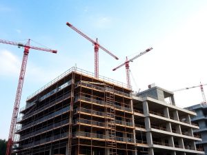 Șantier cu schele și utilaje de construcție.